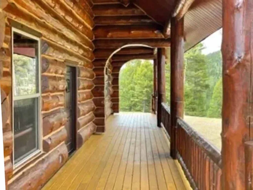 The exterior porch of a log cabin that has been restored