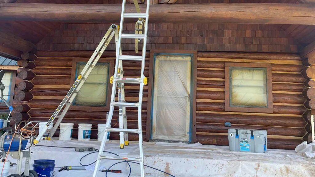 A cabin repair in actions with ladders and equipment set up in front of the home